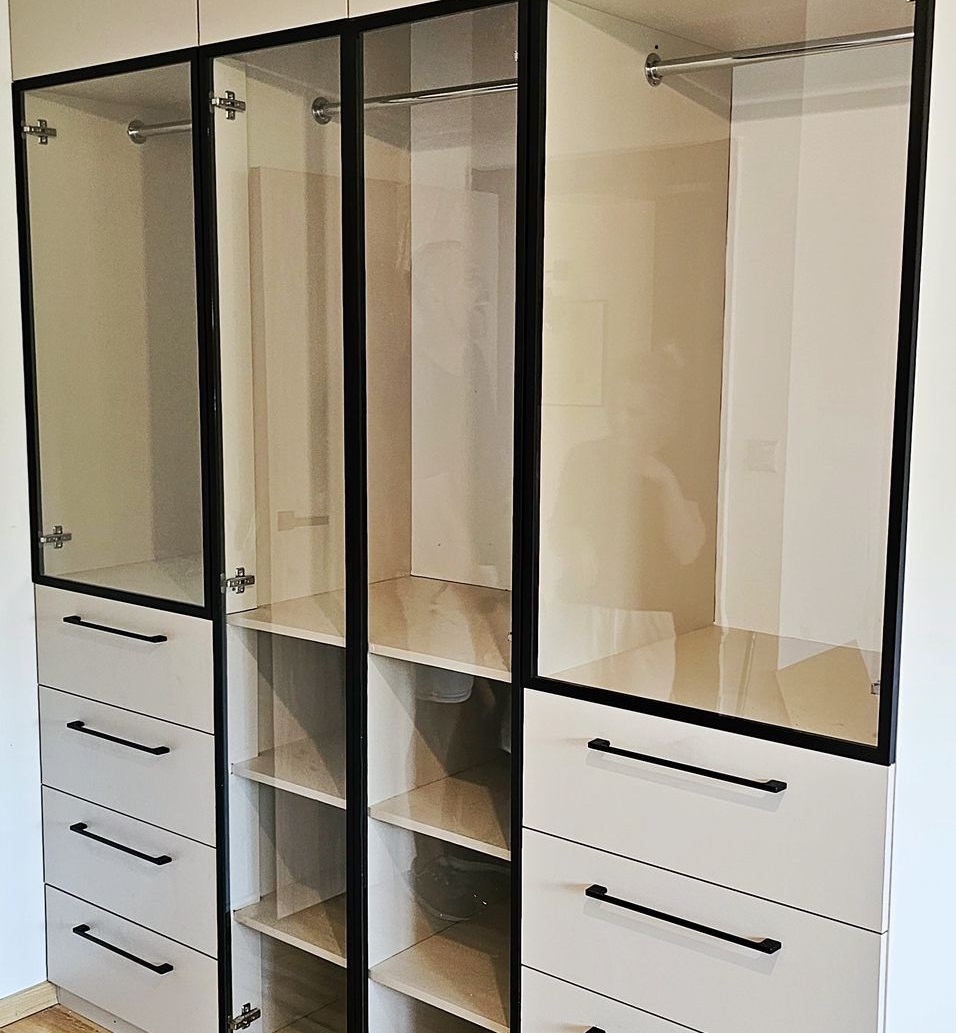 Garderoba ze szklanymi drzwiami i oświetleniem LED w kolorze beżowym. Meble na wymiar w Poznaniu.