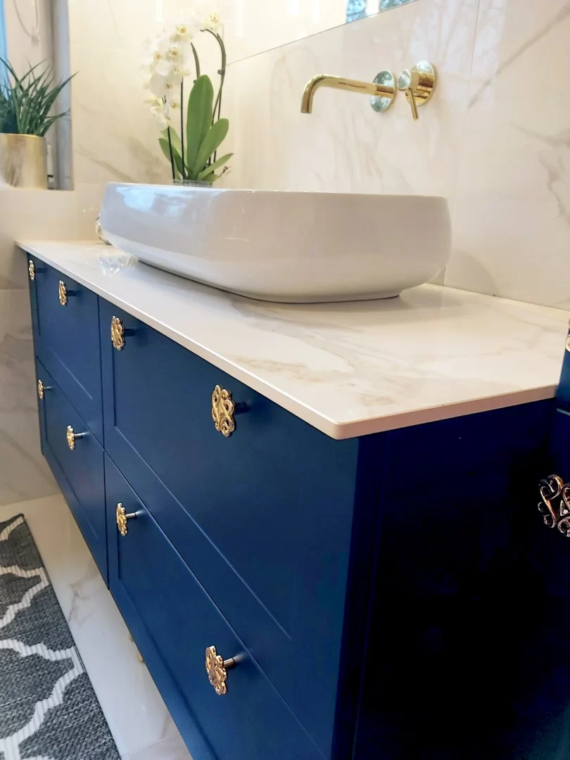 Granatowa szafka art deko na wymiar w Poznaniu, do łazienki ze złotymi uchwytami.