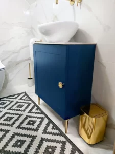 Granatowa szafka art deko na wymiar w Poznaniu, do łazienki ze złotymi uchwytami.