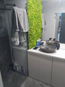 Czarno szara łazienka na zamówienie z zabudową geberitu oraz ścianą z żywego zielonegi mchu