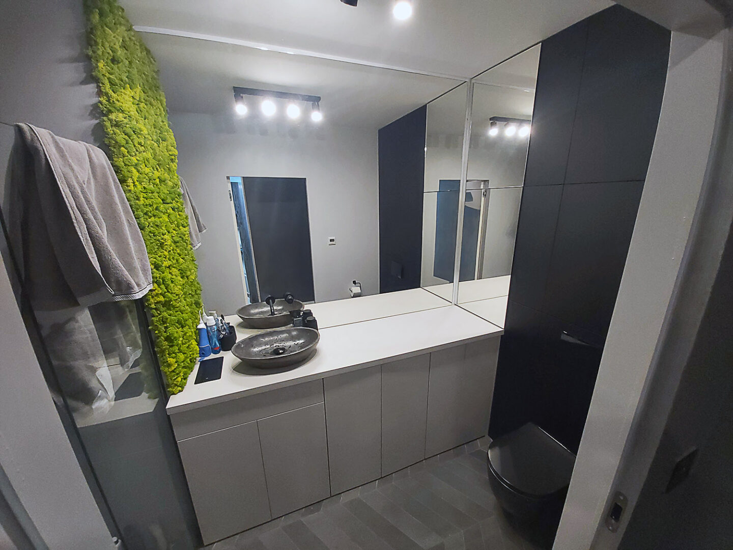 Czarno szara łazienka na zamówienie z zabudową geberitu oraz ścianą z żywego zielonegi mchu