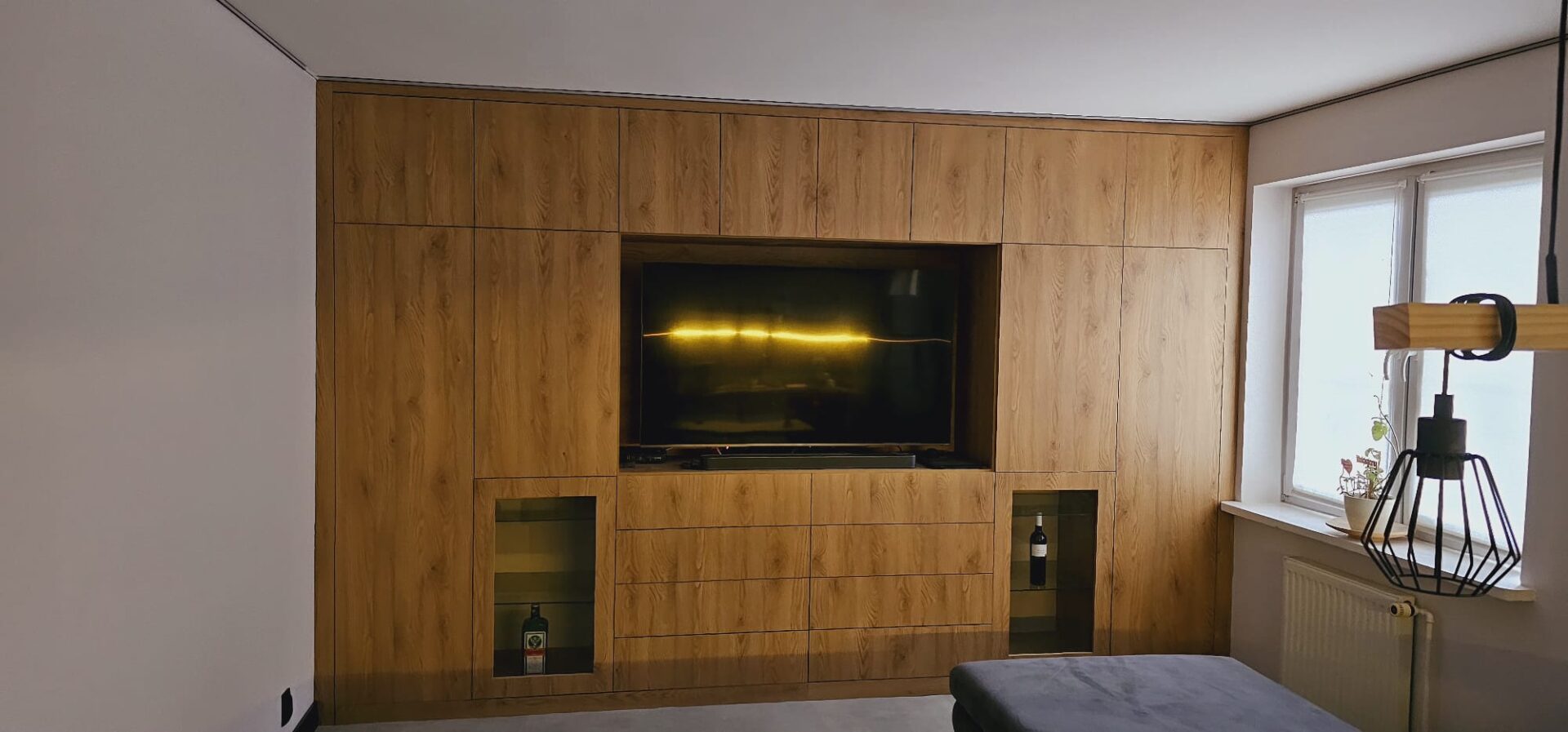 Zabudowa ścienna z panelem telewizora, szafki na wymiar.